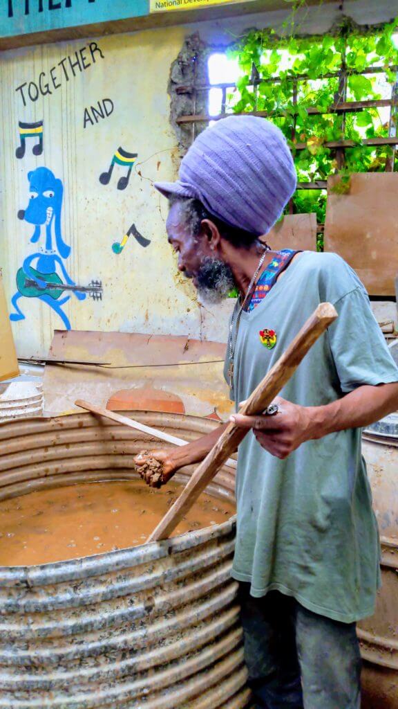 Man washes clay at Trench Town Art and Centre