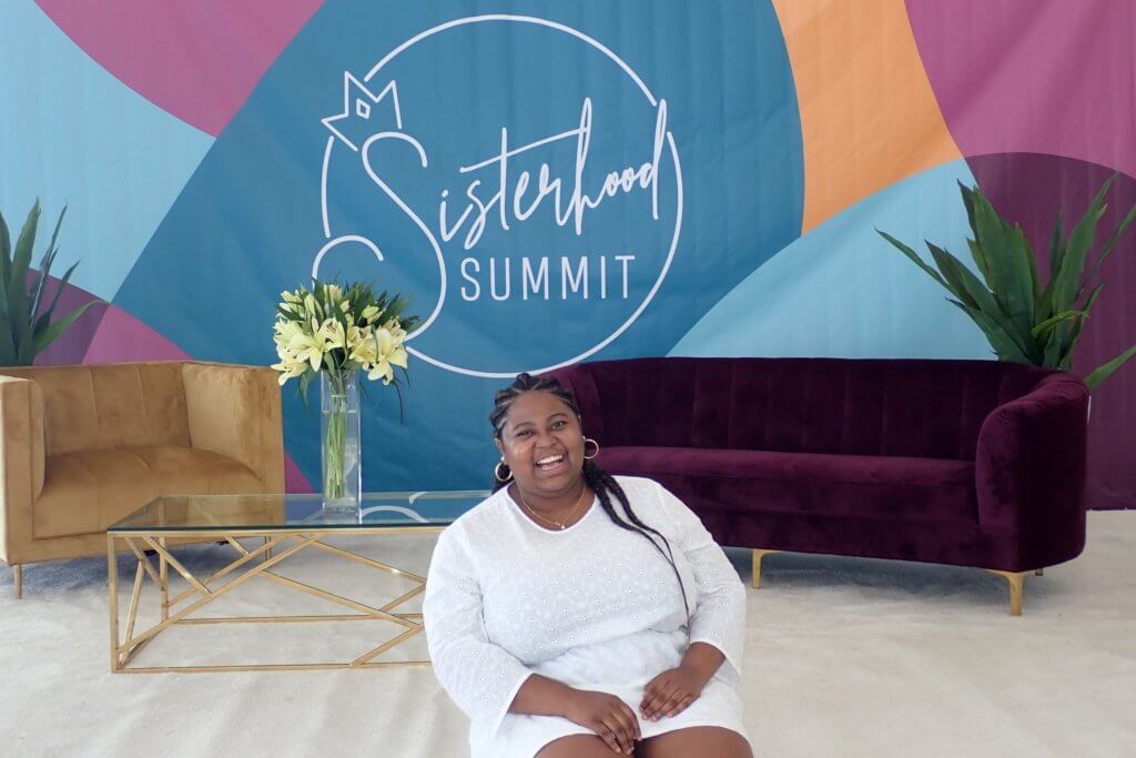 A smiling Diedre McLeod from "Diedre in Wanderland" blog at the Sisterhood Summit in Puerto Rico hosted by Gloria Atanmo. Press and Publications featured image.