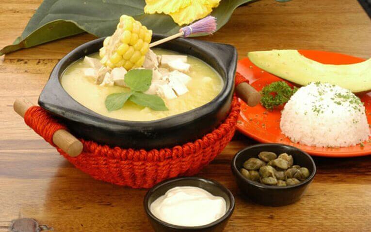 Ajiaco con pollo - hearty soup made from papa criolla and eaten with rice, avocado and capers.  Colombian food you'll love if you're from the Caribbean.